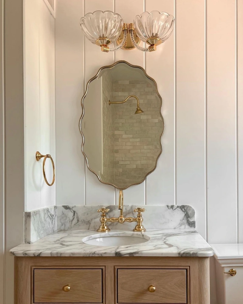 Scalloped Brass-Edged Mirror on Vertical White Paneling