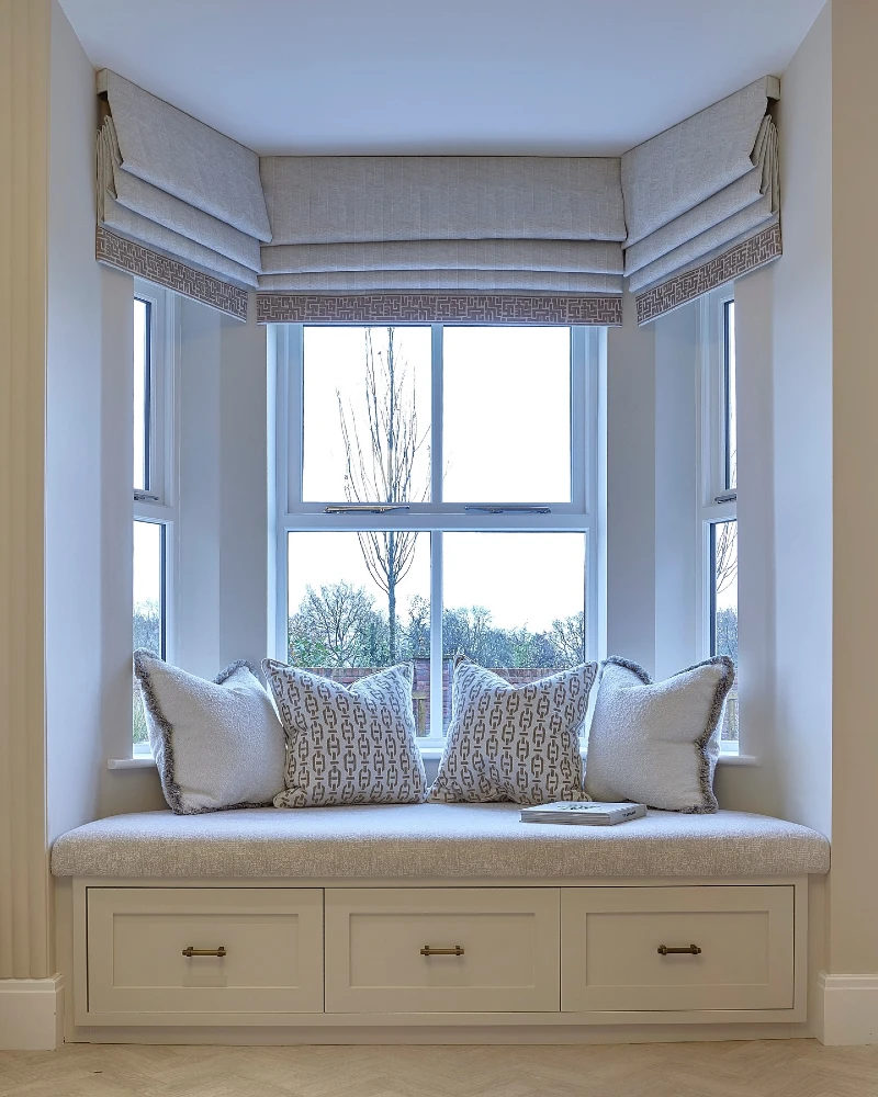 Tailored Roman Shades with Greek Key Trim Around a Window Seat