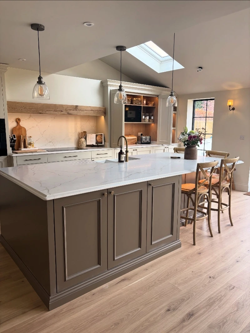 Taupe Paneled Island with Marble Countertop and Tucked Wooden Seating