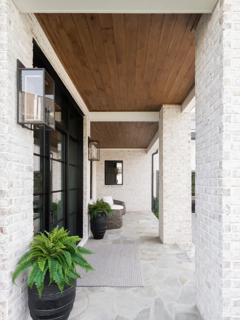 Warm Oak Plank Entryway Overhang with Modern Lantern Sconces