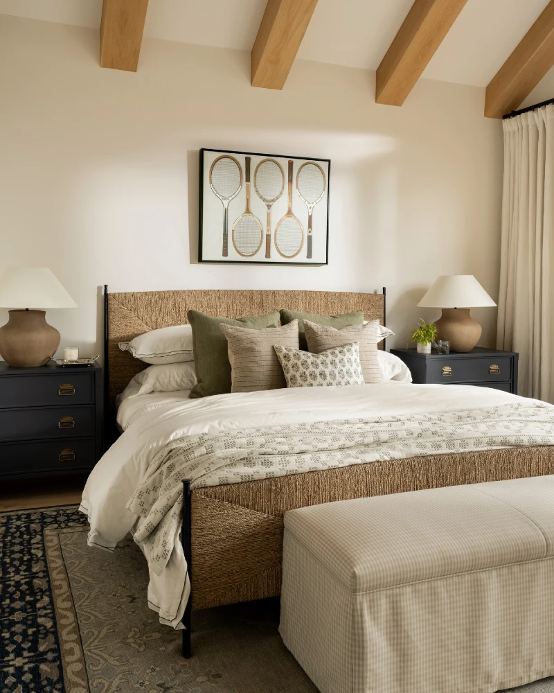 White Bedding with Sage Pillows and a Woven Natural Fiber Headboard