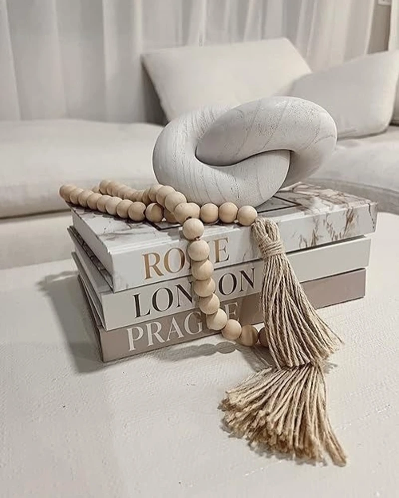 Wooden Interlocking Knot and Beaded Garland on Designer Books